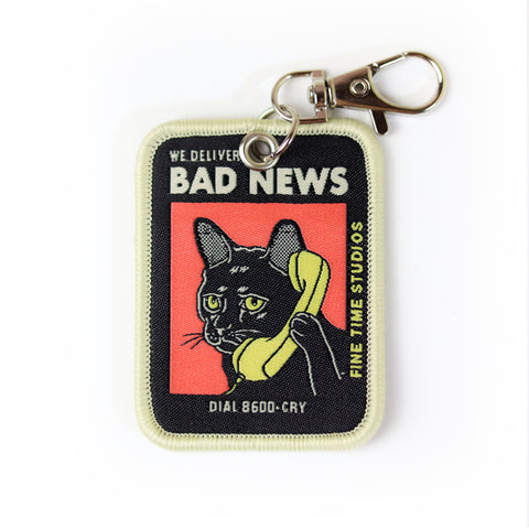 We Deliver Bad News Keychain